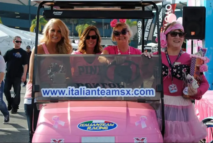Le ragazze dell'Italianteam su un golf cart rosa nel paddock